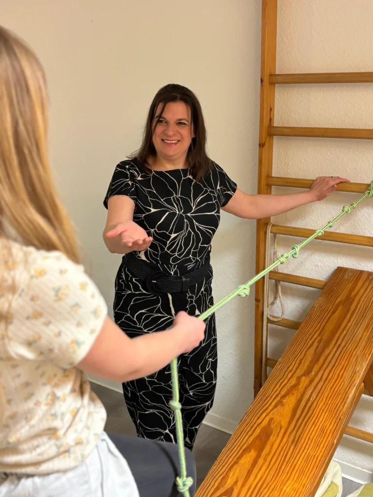 Kind balanciert an der Sprossenwand in der Ergotherapiepraxis